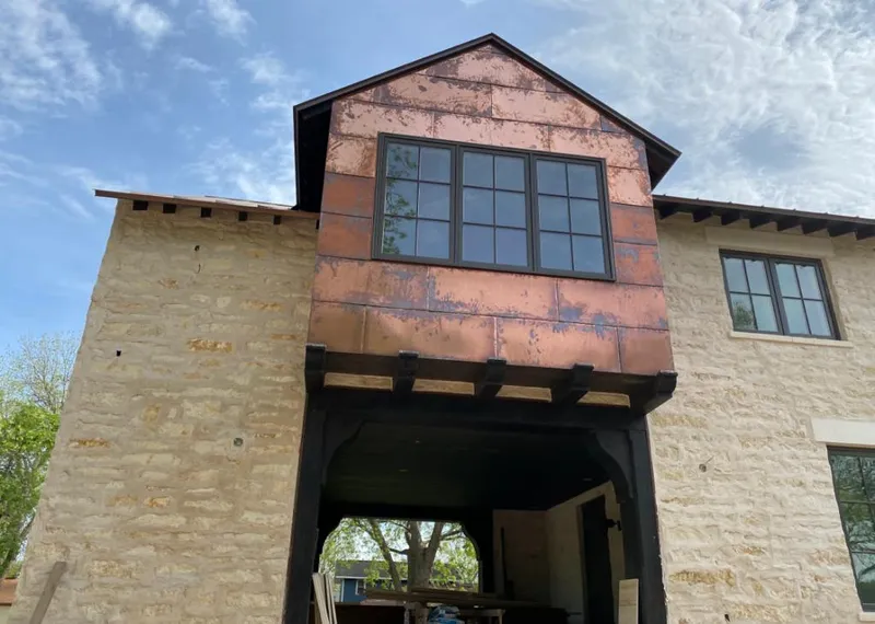 Copper metal panel facade on a stone building for Skylight Installation in Fulshear