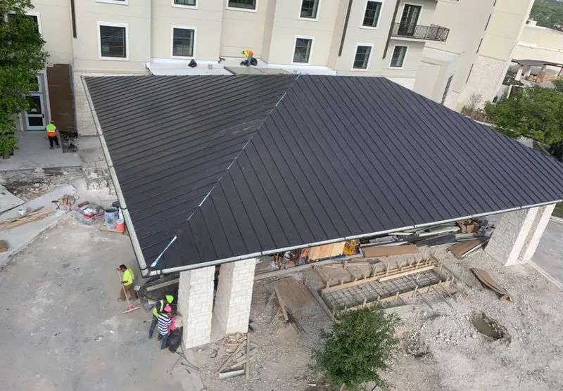 Metal roofing installation team working on a commercial building in Fulshear